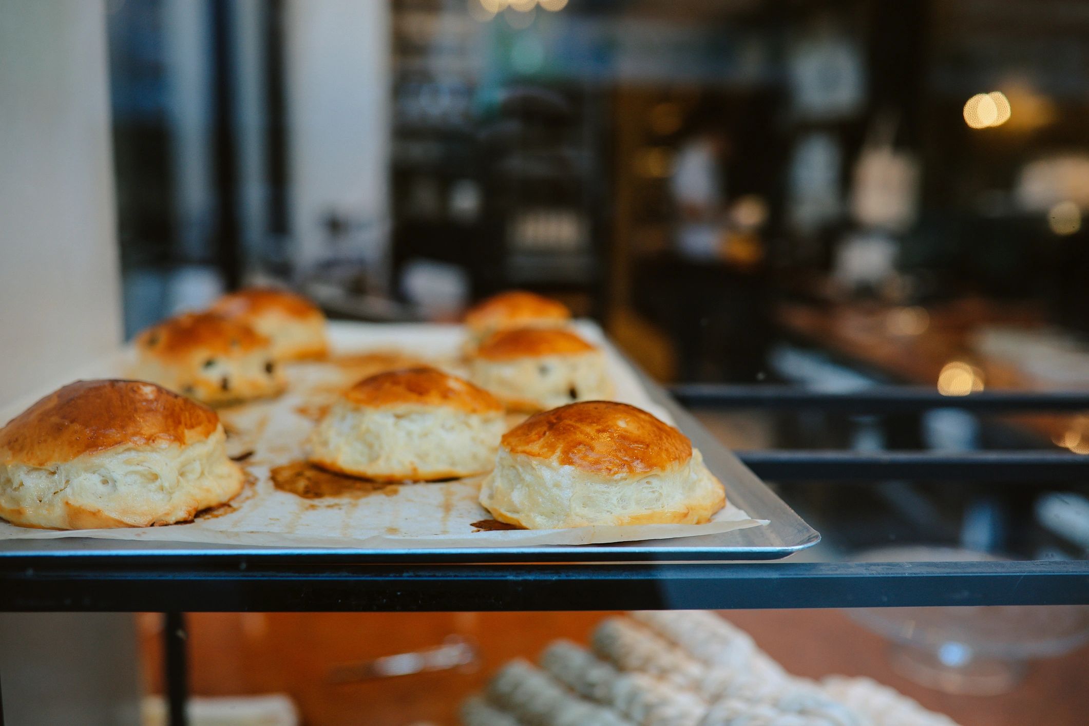 Fresh brioche buns displayed in a bakery case