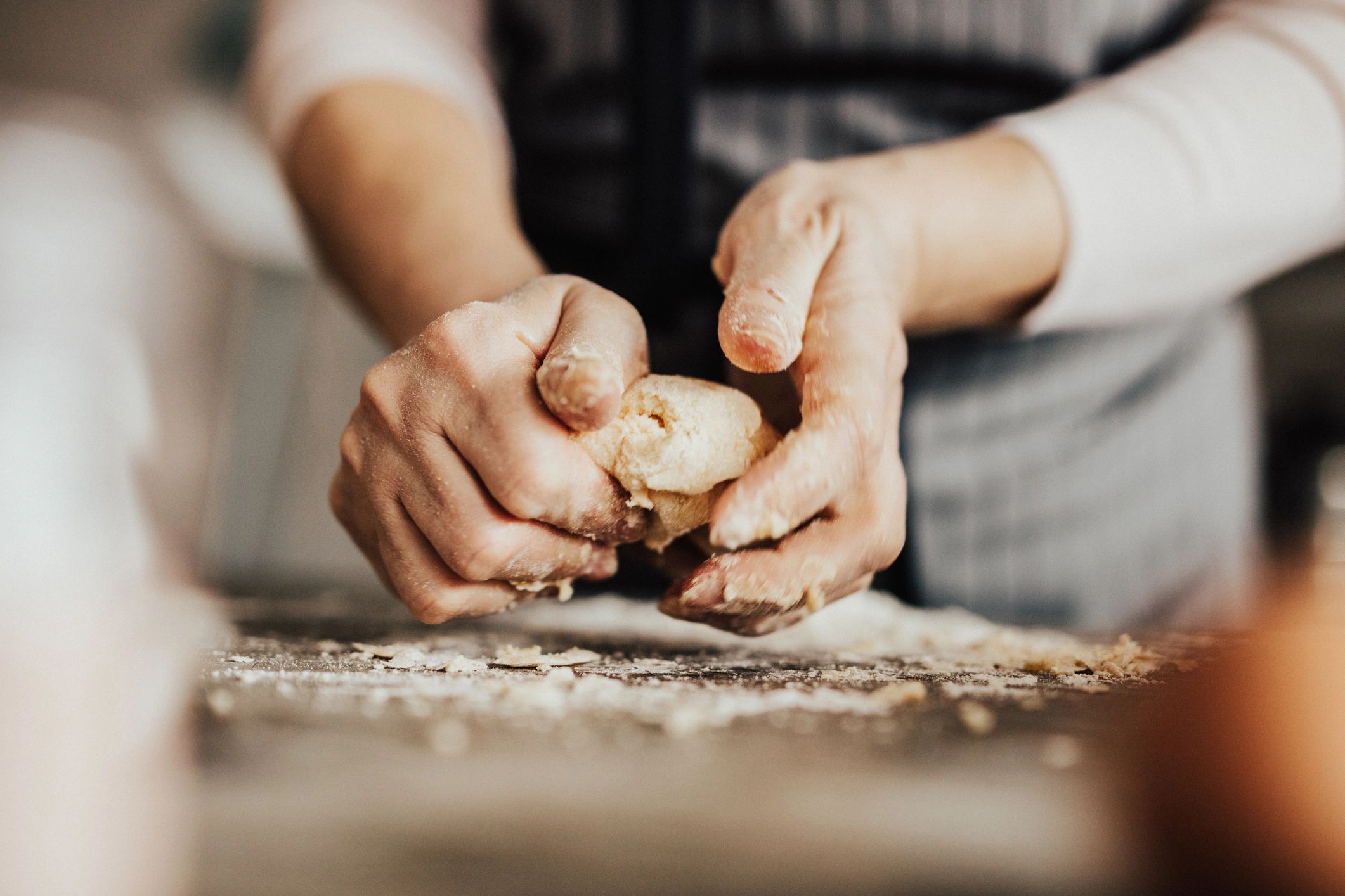 Hands kneading dough on a floured surface